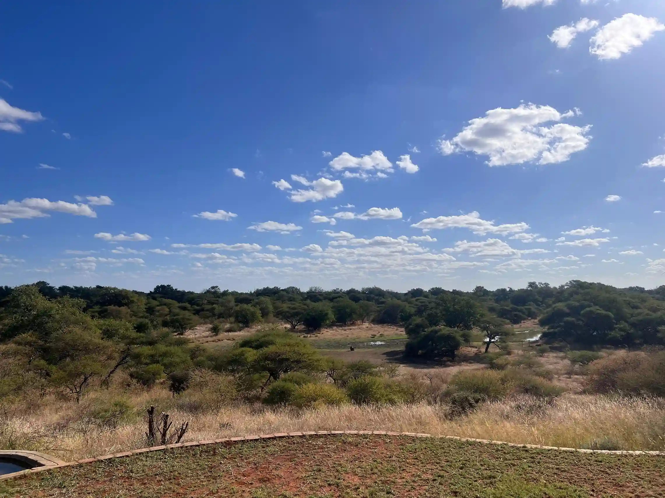 ntorno natural del lodge al atardecer, con edificios de estilo africano rodeados de naturaleza y total tranquilidad.